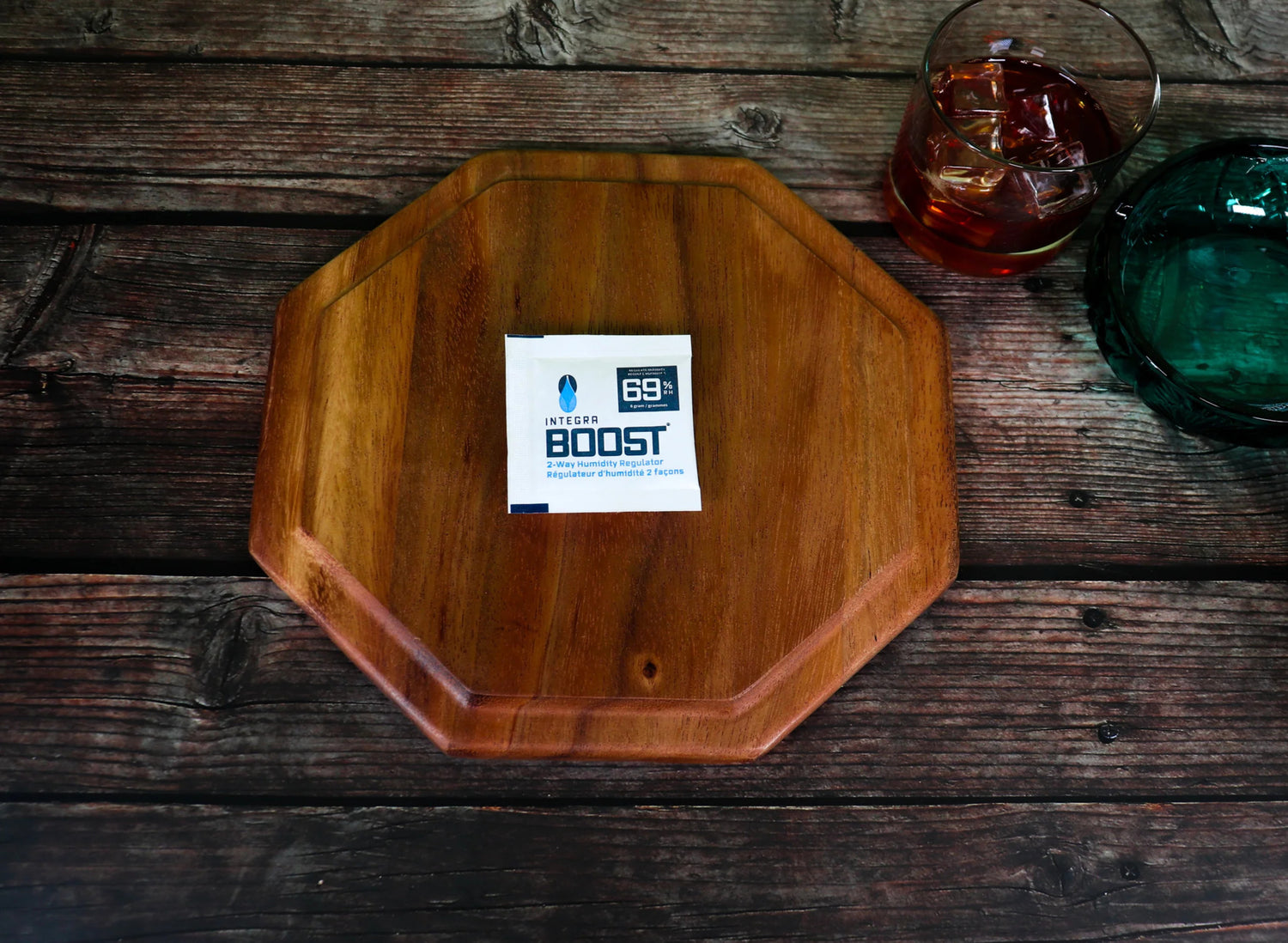 Various bottles and jars with labels, cannabis leaves, buds, a keyboard, and a white cylindrical device on a light green surface